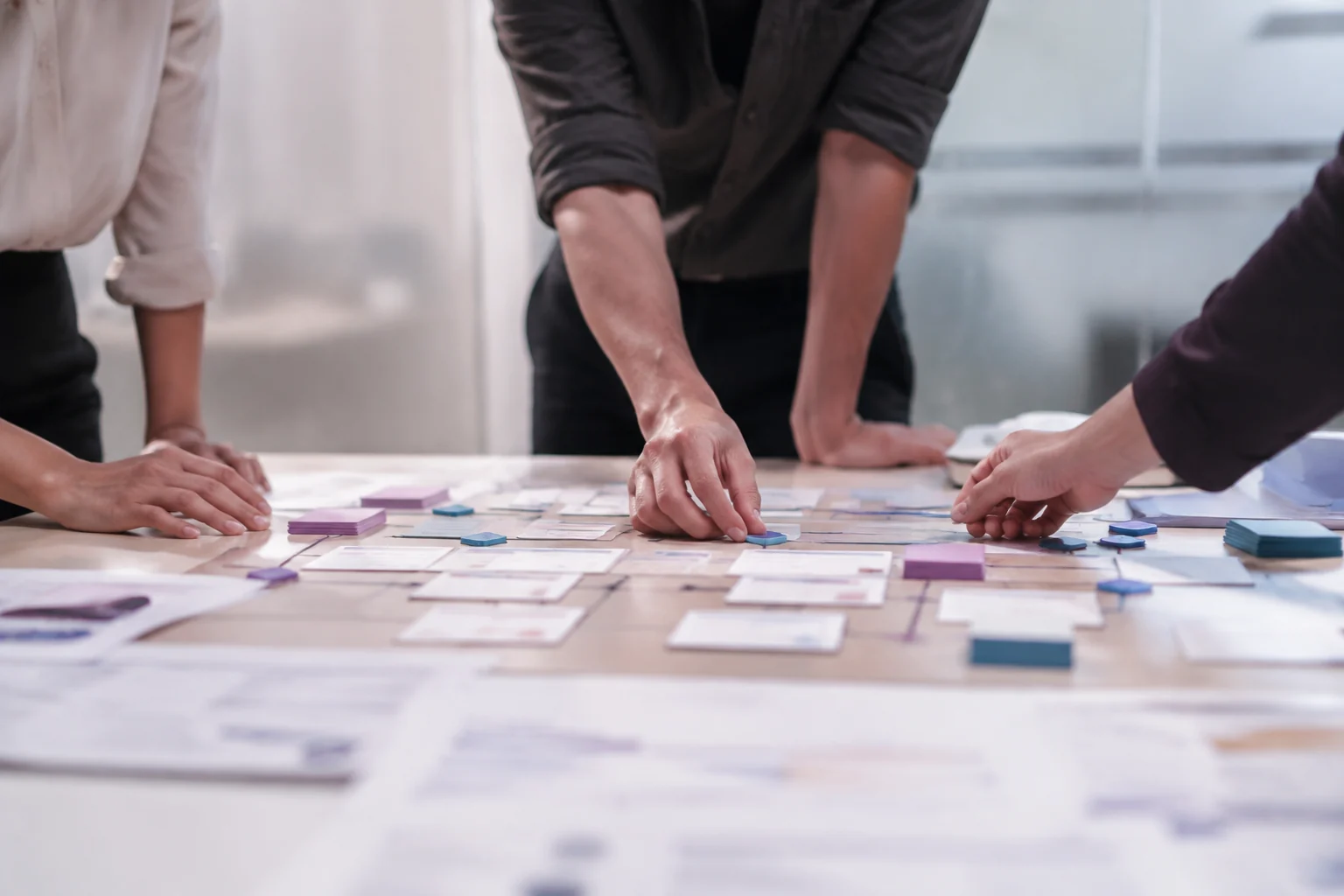 Personas organizando las etapas de un proceso sobre una mesa de trabajo.